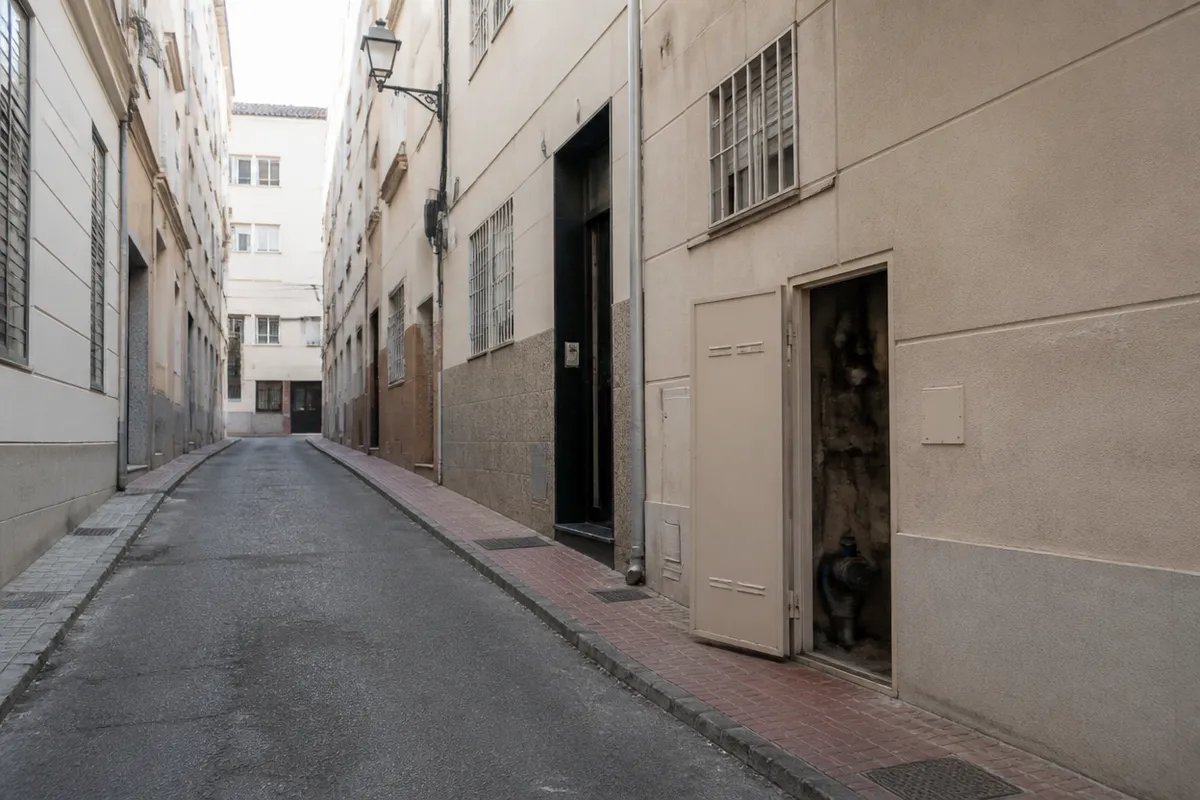 Calle residencial de Murcia con acceso a un cuarto de instalaciones durante un trabajo de fontanería